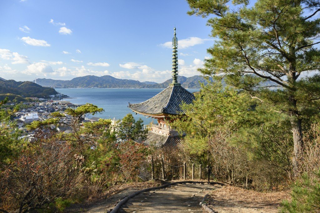 The pagoda rising above trees with the Seto Inland Sea and islands beyond
