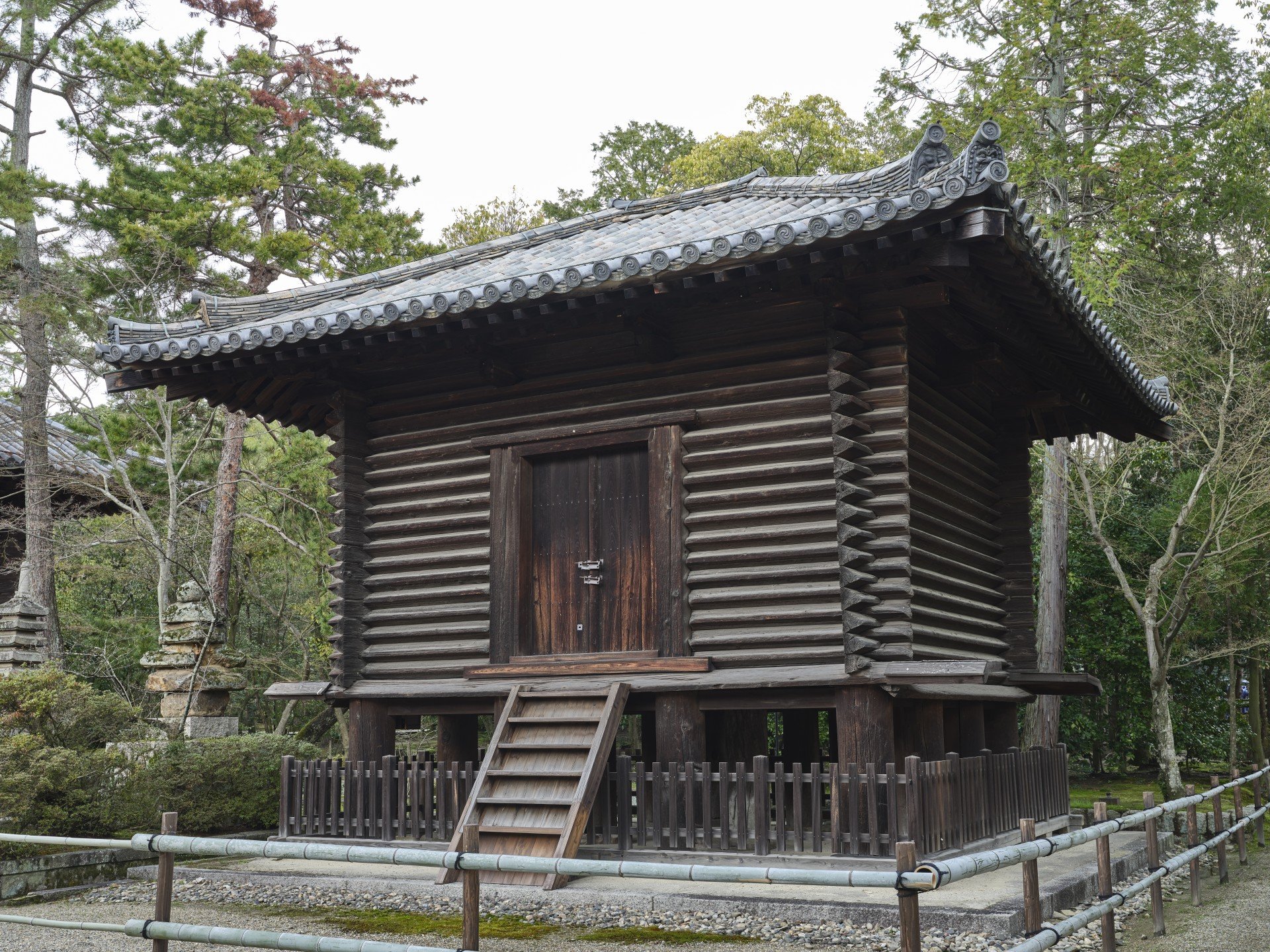 The raised log-built sutra repository with a wooden stair at the front